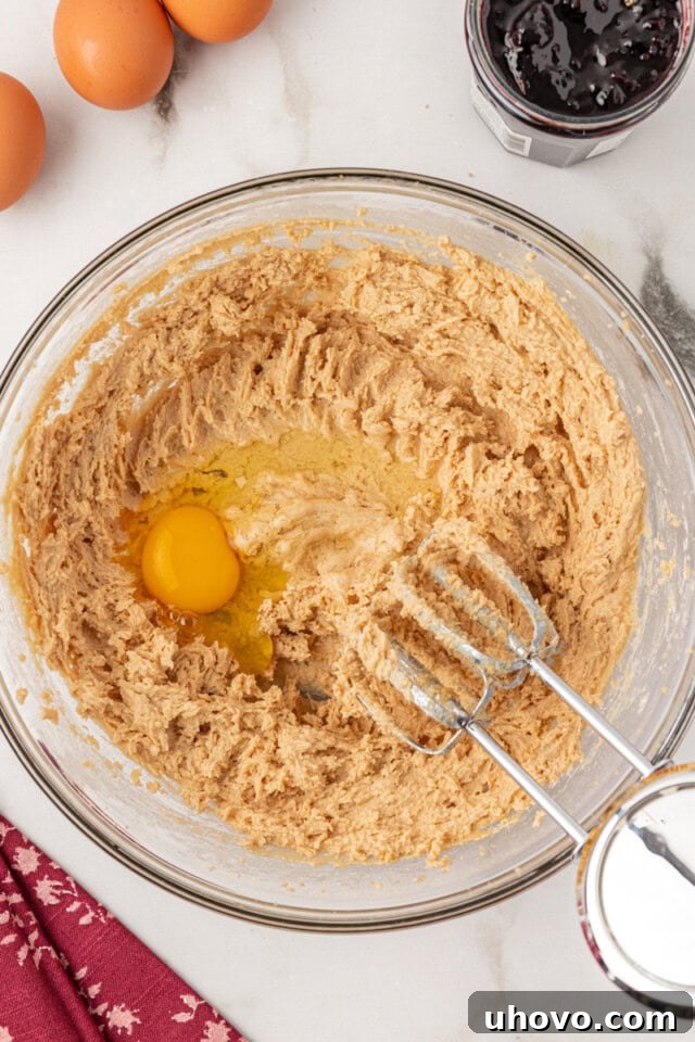 overhead view of egg added to creamed butter and brown sugar