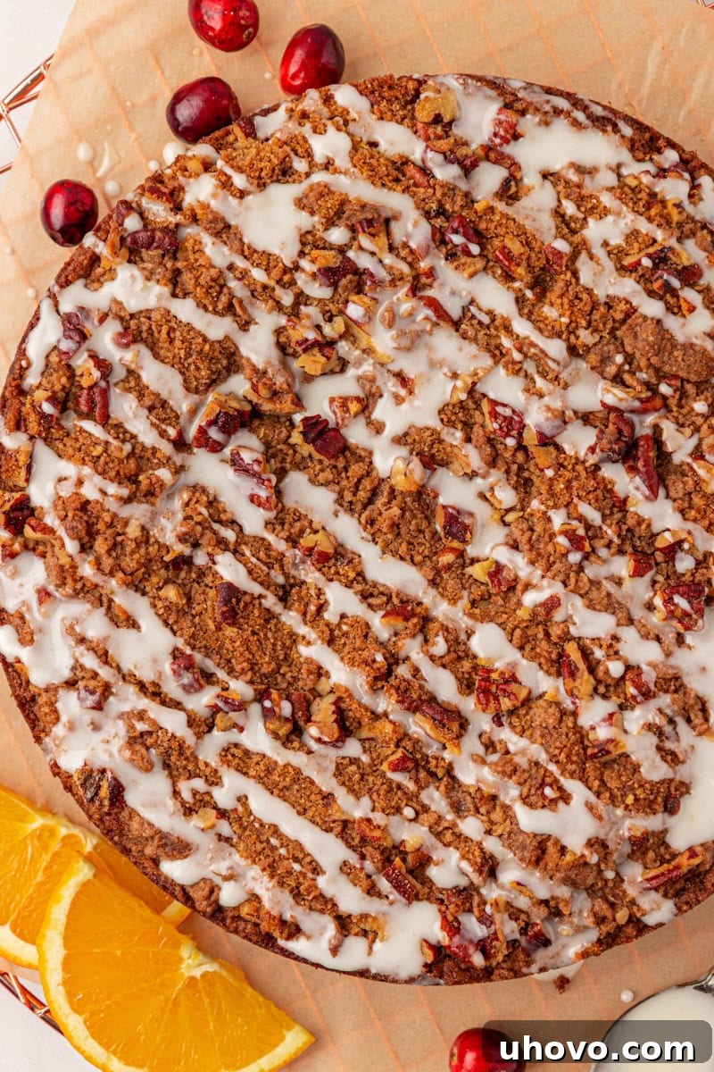 A perfectly baked cranberry coffee cake, beautifully topped with a simple, elegant orange glaze, ready to be served as a delightful treat.