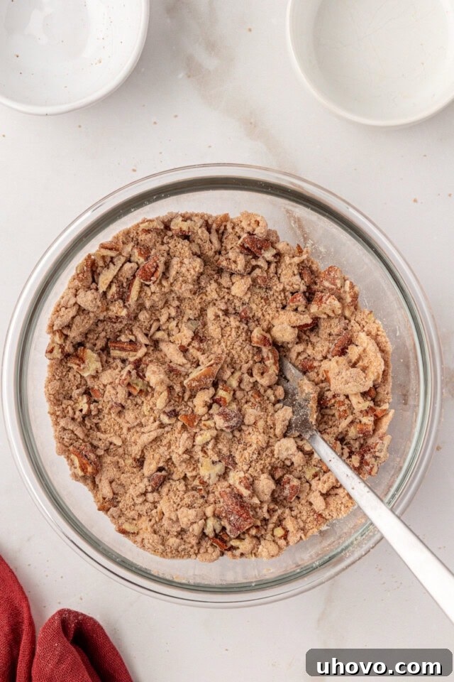 Overhead view of the crumbly streusel mixture in a glass bowl after butter has been cut in and nuts (if used) have been stirred.