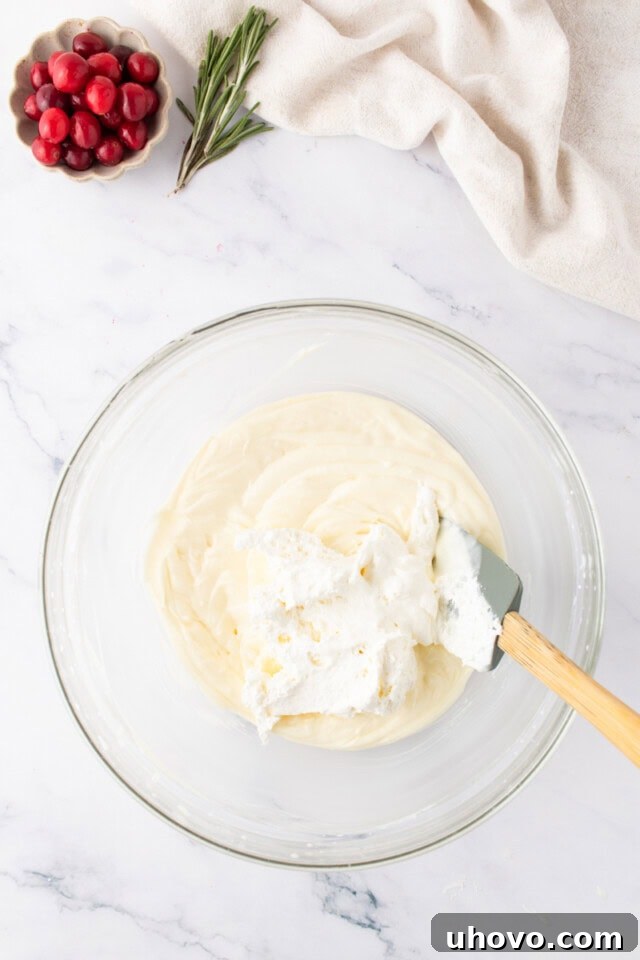 overhead view of whipped cream added to no-bake cheesecake mixture