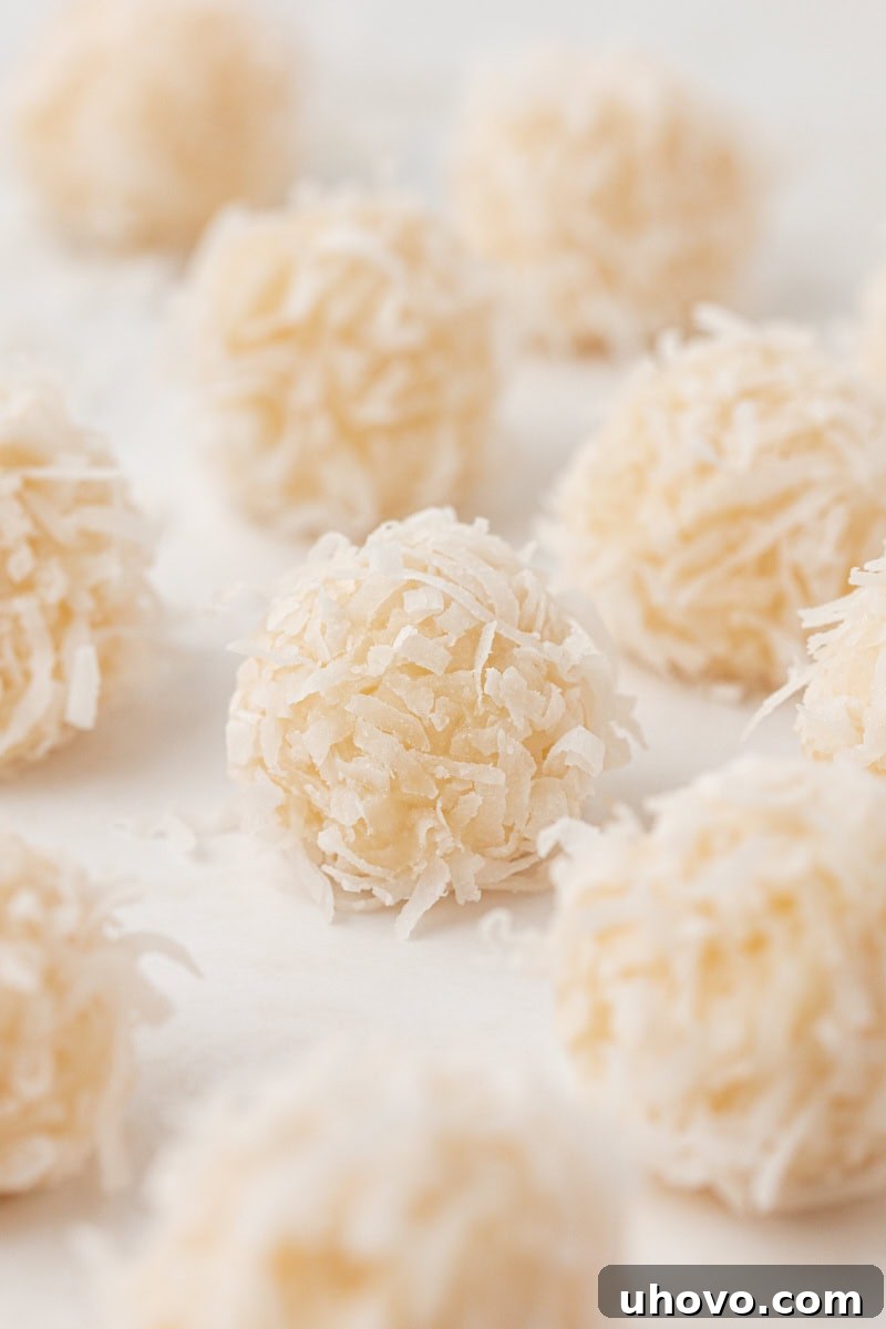 close up of coconut snowballs on a white surface