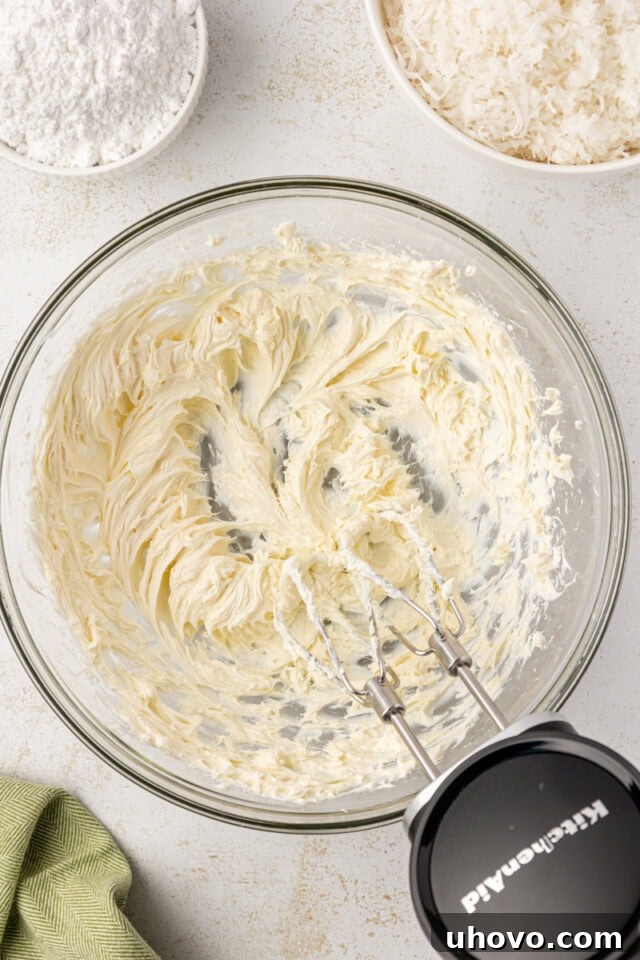 overhead view of beaten cream cheese in a glass mixing bowl
