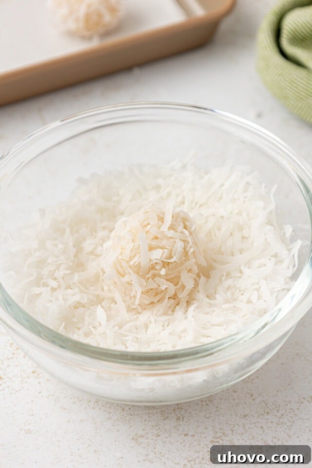 a coconut snowball in a bowl of shredded coconut
