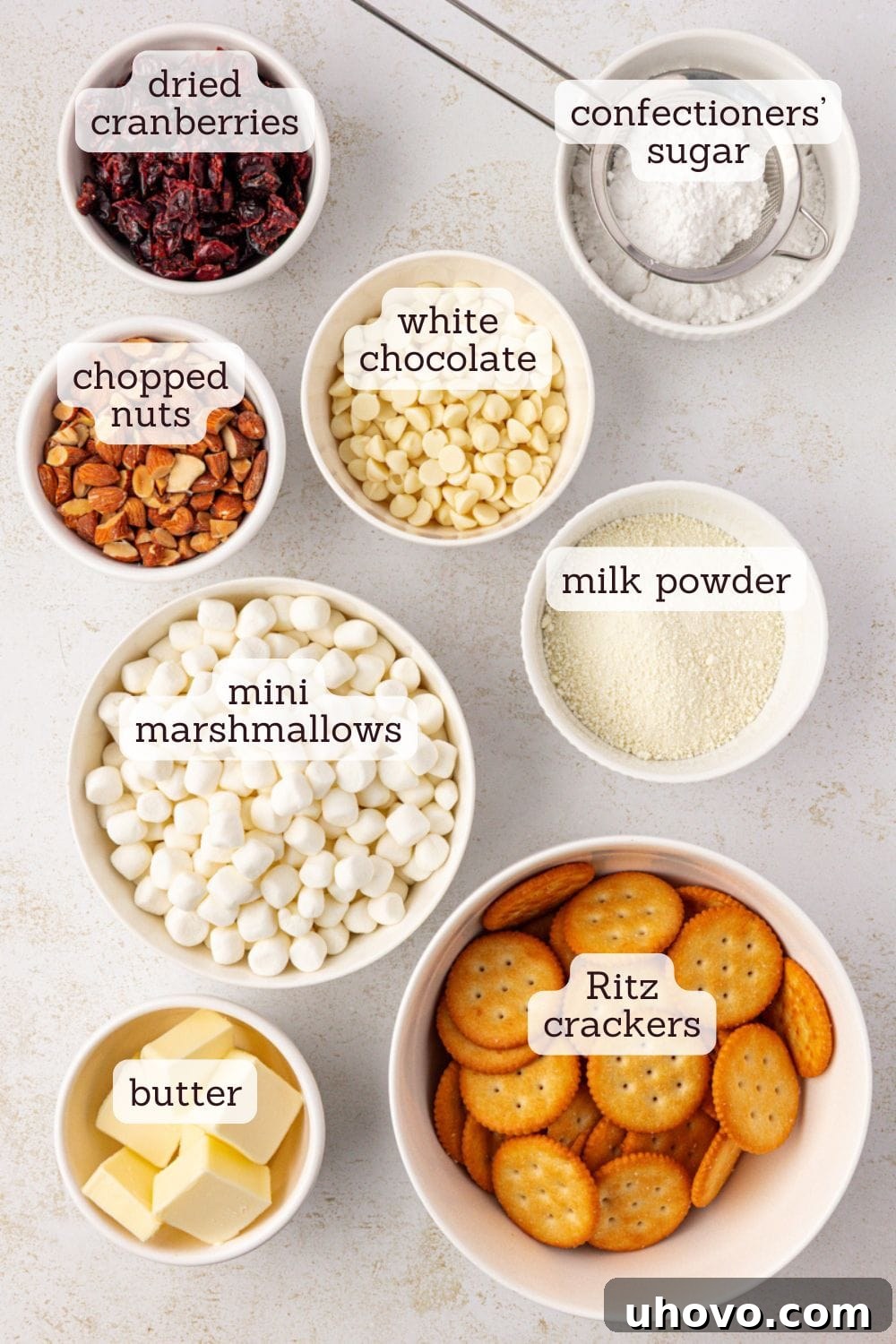 Overhead view showcasing the organized ingredients for Snowflake Crisp, including buttery crackers, mini marshmallows, white chocolate, milk powder, dried cranberries, and chopped nuts.