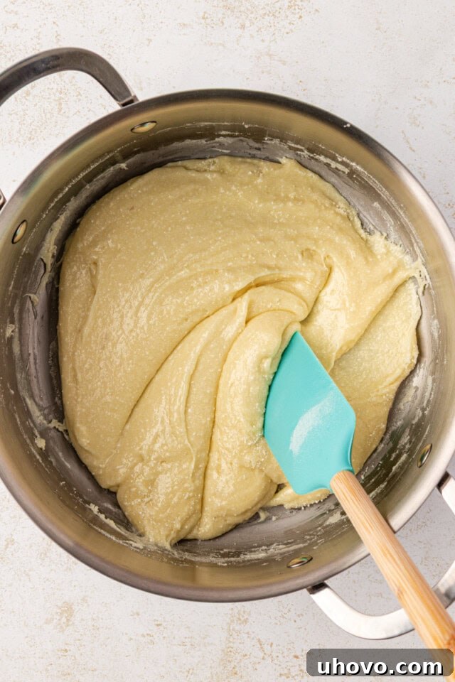 Close-up overhead view of the smooth Snowflake Crisp base mixture in a large saucepan after milk powder has been stirred in.