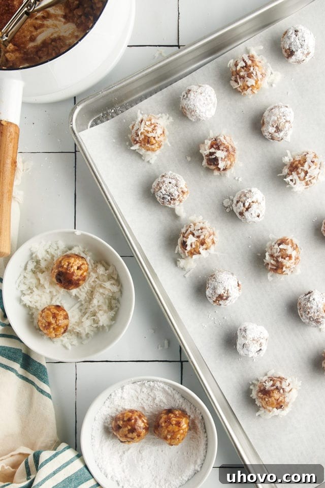 Overhead view of Rice Krispie date balls being rolled in a bowl of powdered sugar and another bowl of shredded coconut