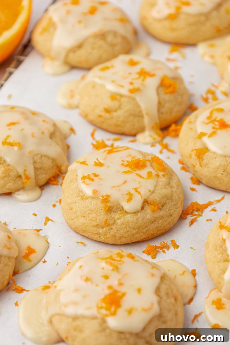 glazed orange cookies on white parchment paper