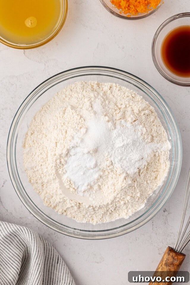 overhead view of flour, baking powder, baking soda, and salt in a mixing bowl