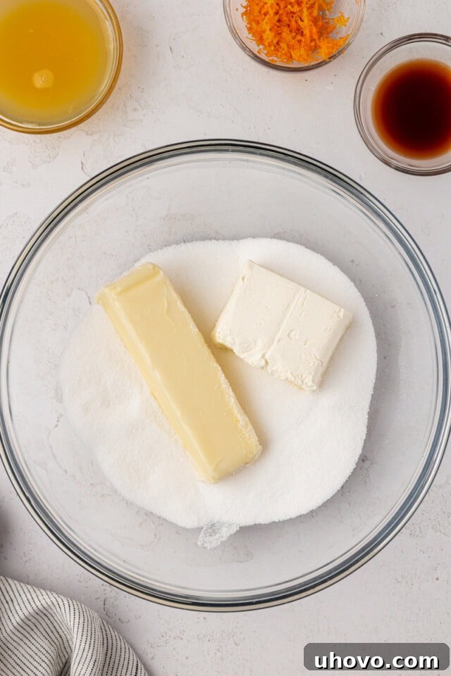overhead view of butter, cream cheese, and sugar in a mixing bowl