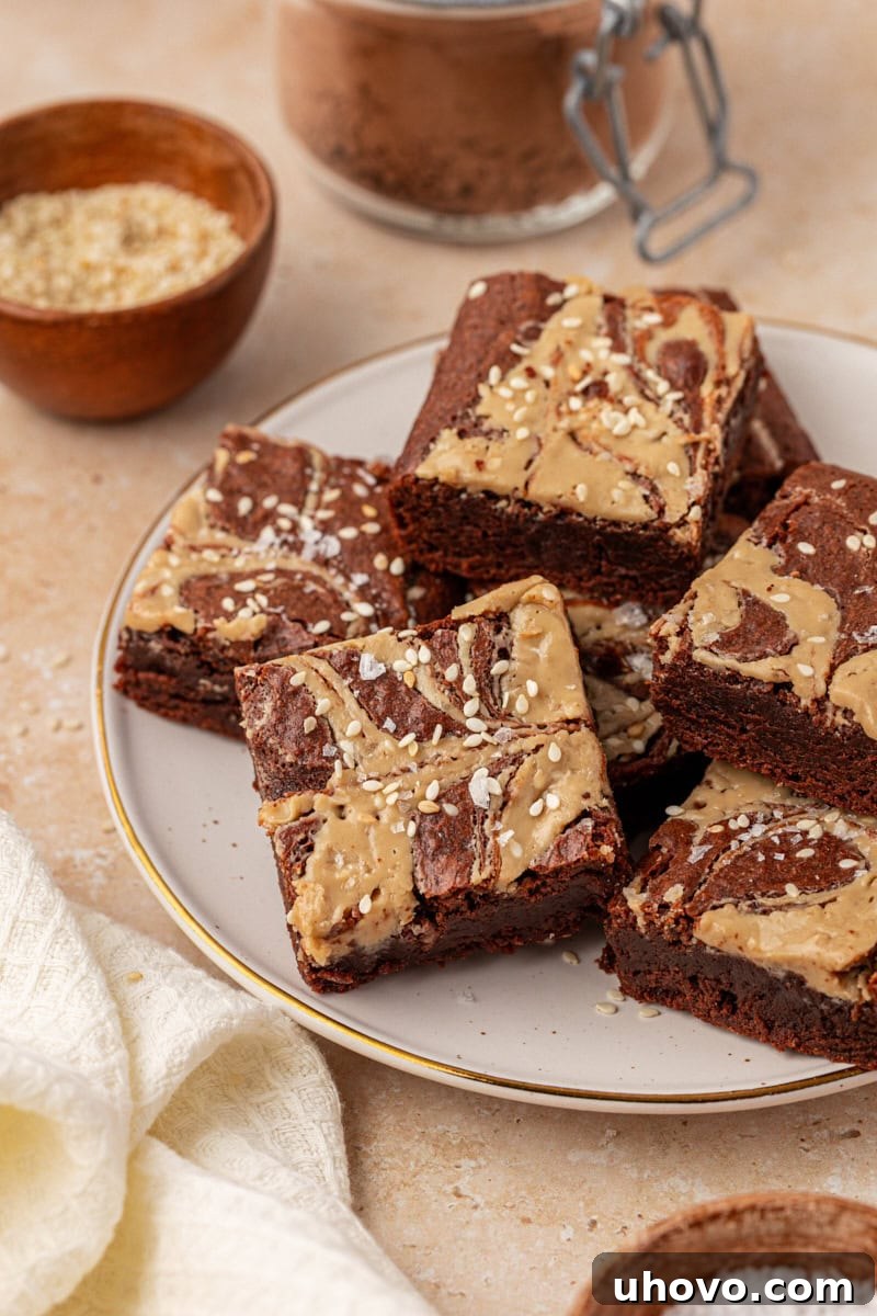 tahini brownies in a stacked pile on a white plate
