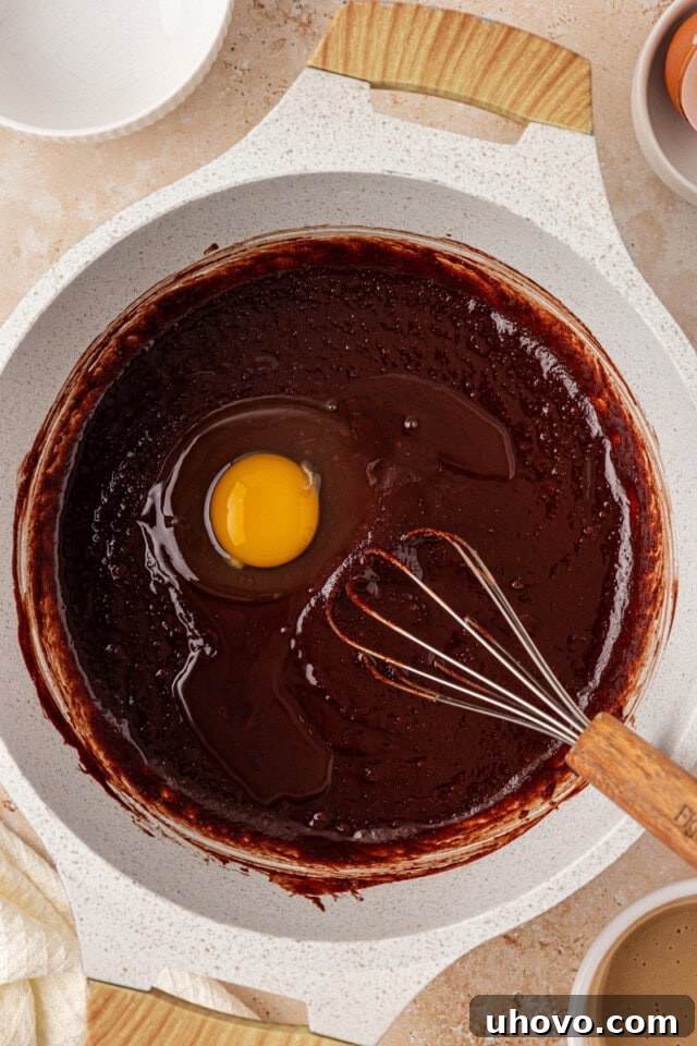 overhead view of egg added to brownie mixture