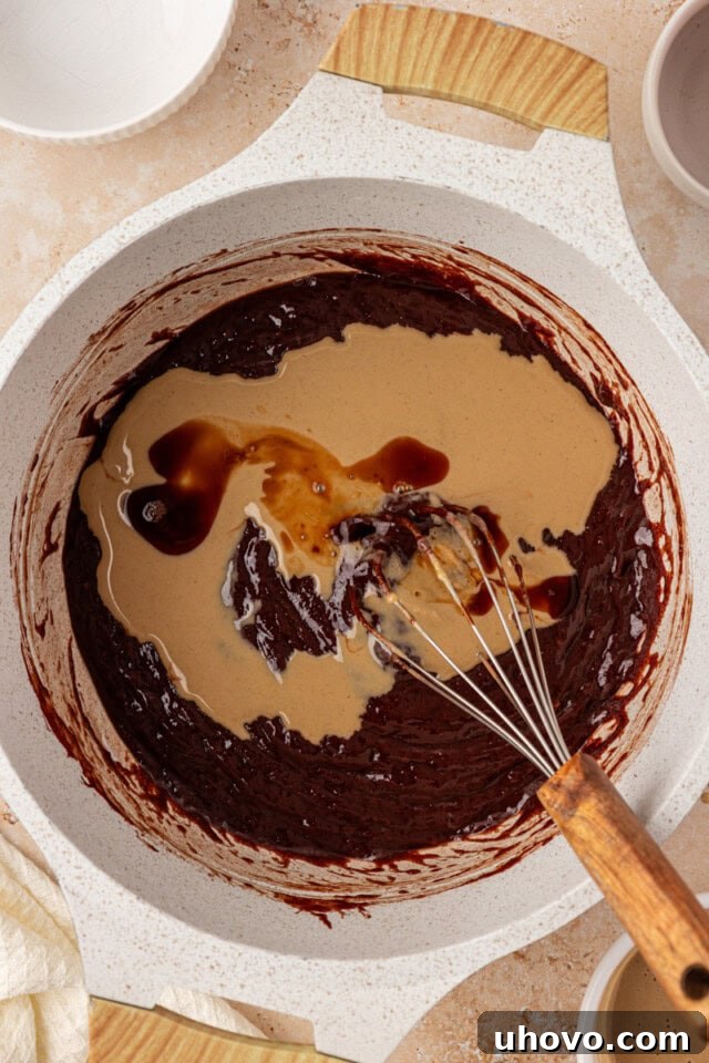overhead view of tahini and vanilla added to chocolate mixture for tahini brownies