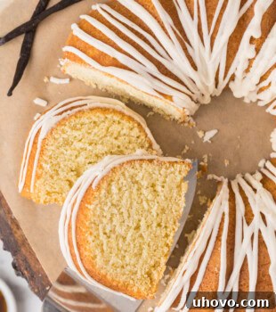 partially sliced vanilla Bundt cake topped with a smooth vanilla glaze