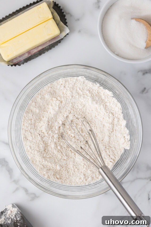overhead view of flour, baking powder, baking soda, and salt whisked together in a mixing bowl