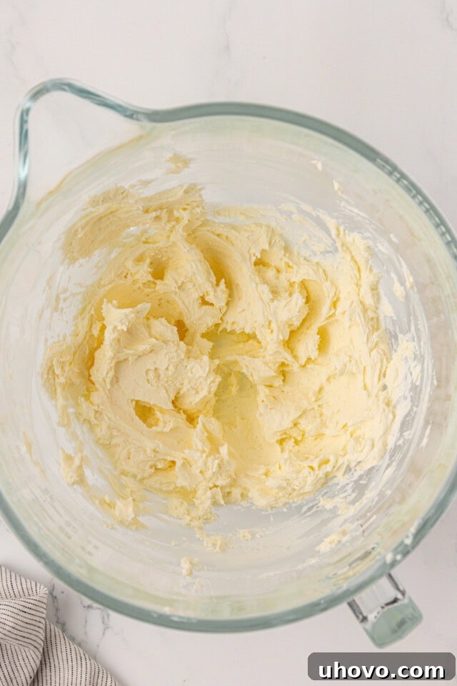 overhead view of beaten cream cheese and butter in a mixing bowl