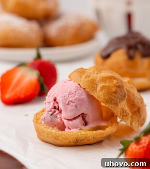A partially assembled profiterole filled with luscious strawberry ice cream, showcasing the potential for customization.