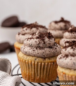 cookies and cream cupcakes topped with Oreo buttercream and cookie crumbs on a wire rack