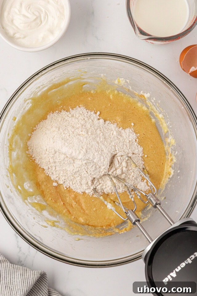 overhead view of dry ingredients added to wet ingredients for cookies and cream cupcakes