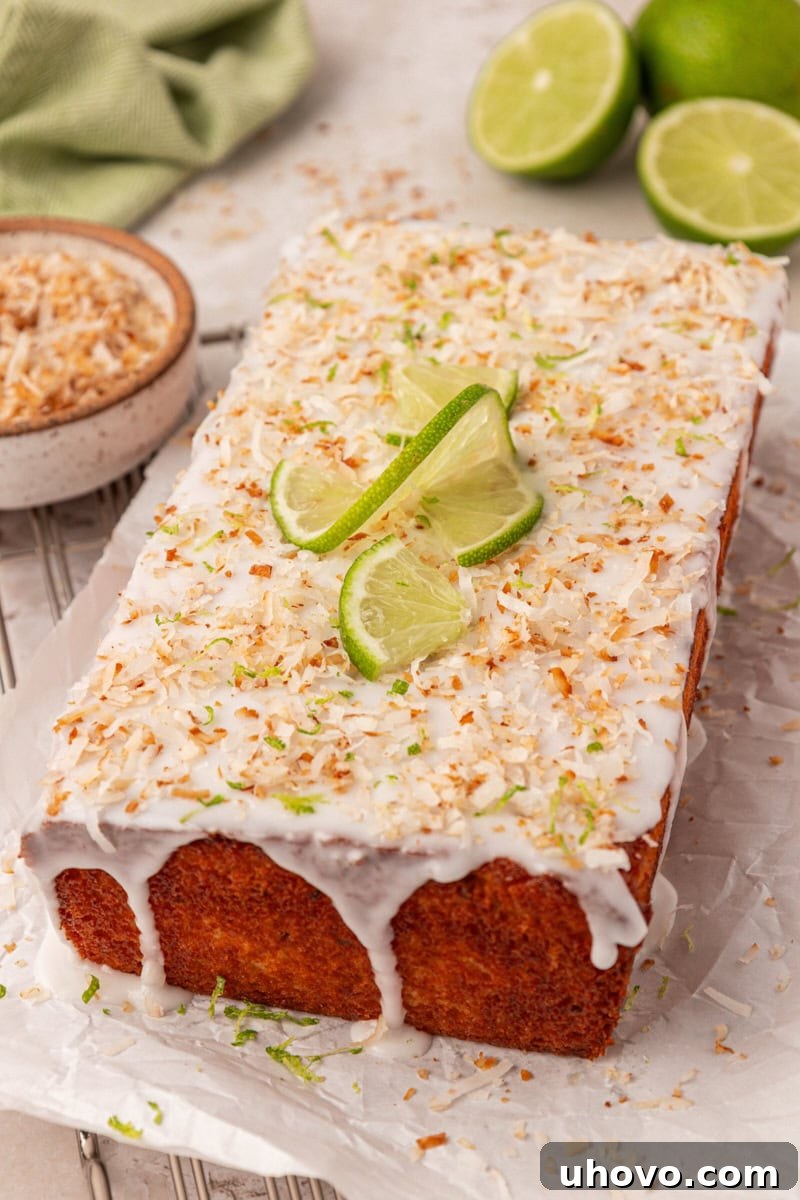 Coconut lime loaf cake with thick lime glaze, coconut flakes, lime zest, and lime slices