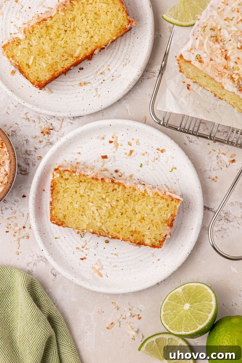 Slice of coconut lime cake topped with lime glaze, toasted coconut, and lime zest