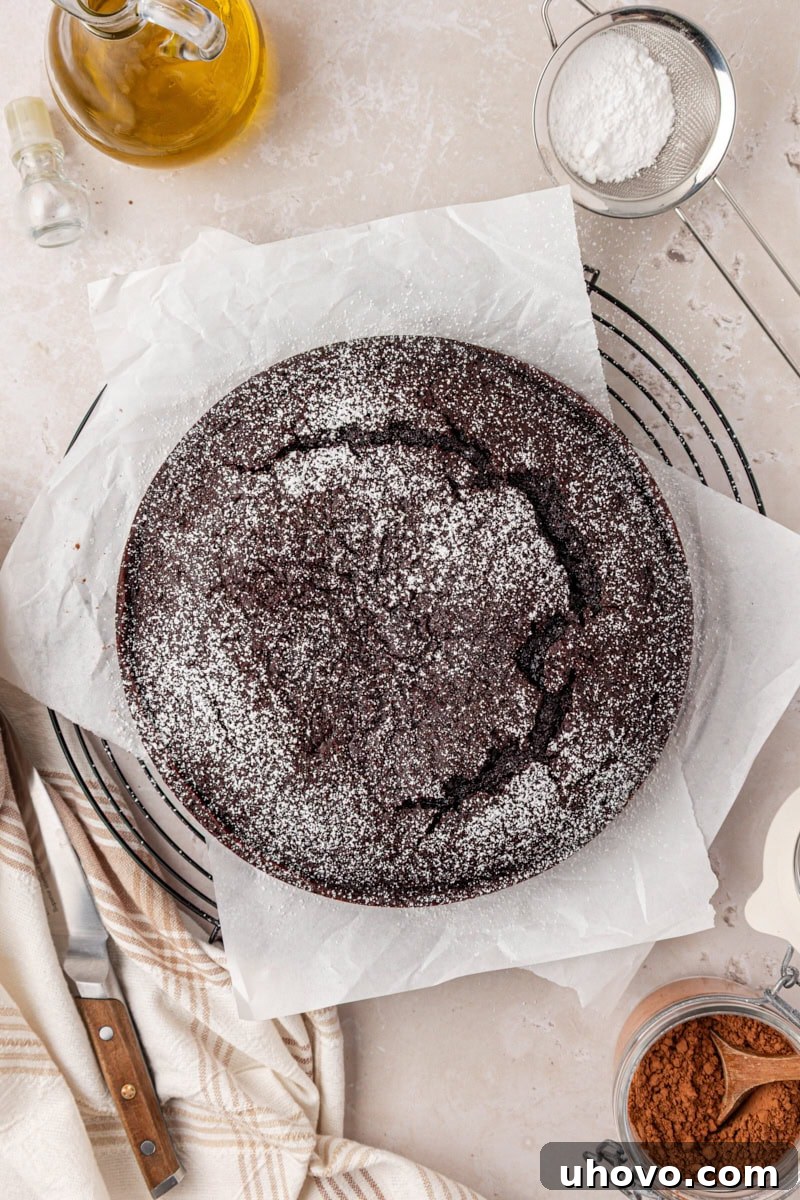 An overhead view of the entire chocolate olive oil cake, beautifully dusted with powdered sugar, ready to be served.