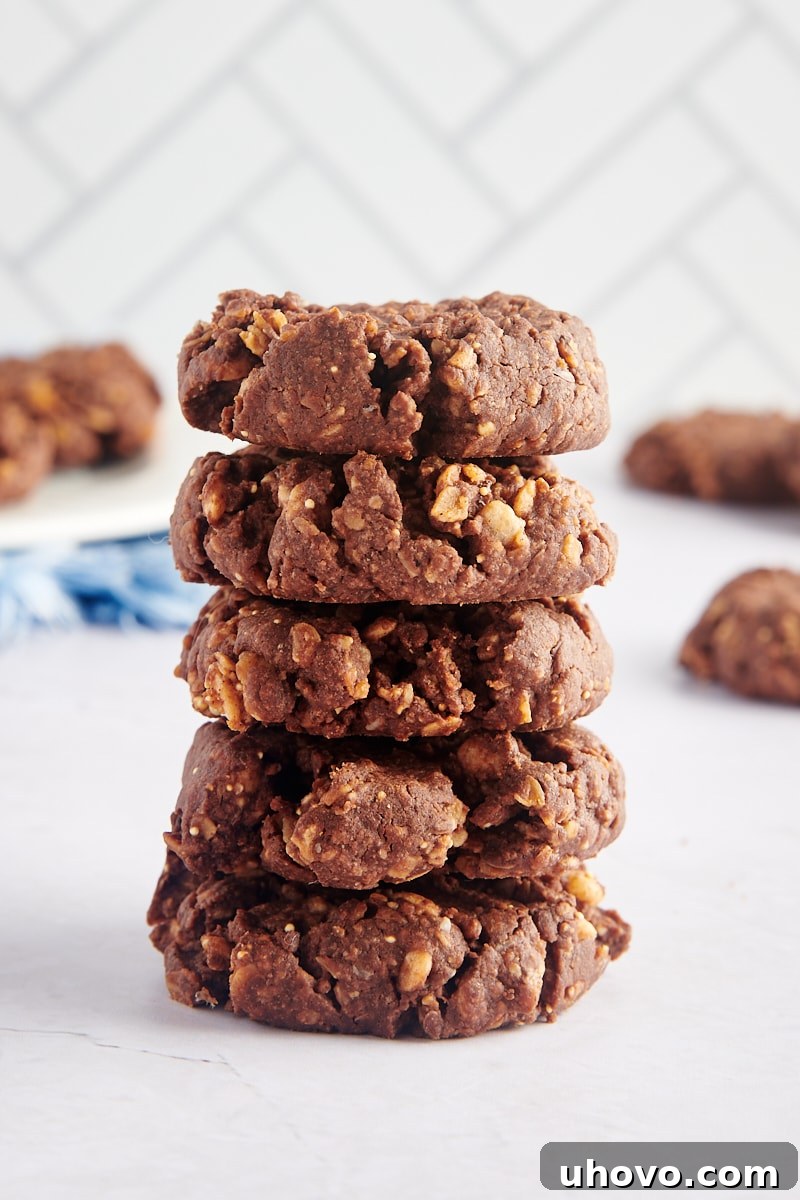 A stack of five thick, chewy chocolate peanut butter granola cookies, perfect for a delicious treat.