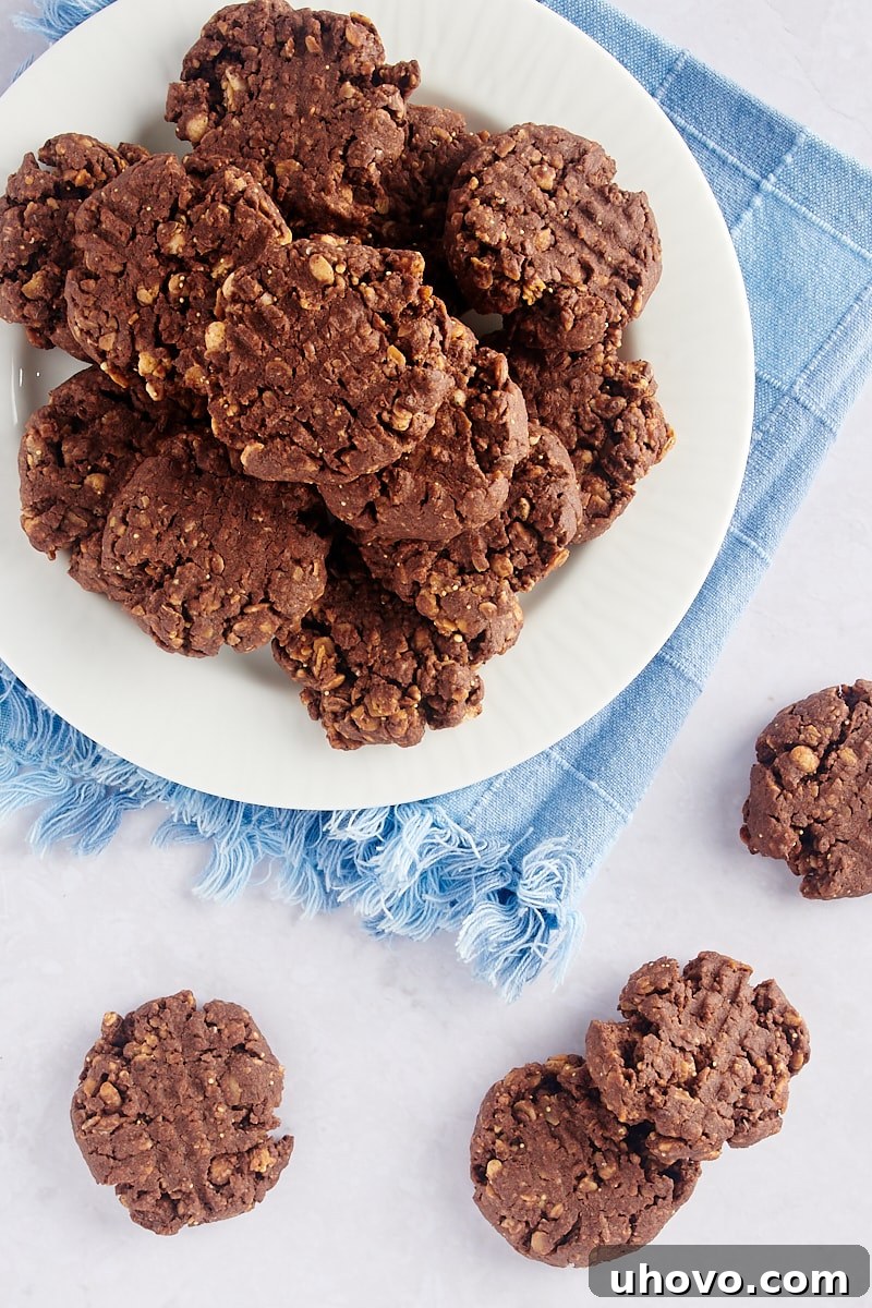 Overhead view of chocolate peanut butter granola cookies casually arranged on a plate and rustic tabletop, ready for serving.