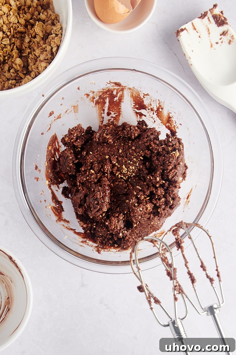 Smooth, creamy cookie dough in a mixing bowl, showing the consistency before the addition of whole granola pieces.