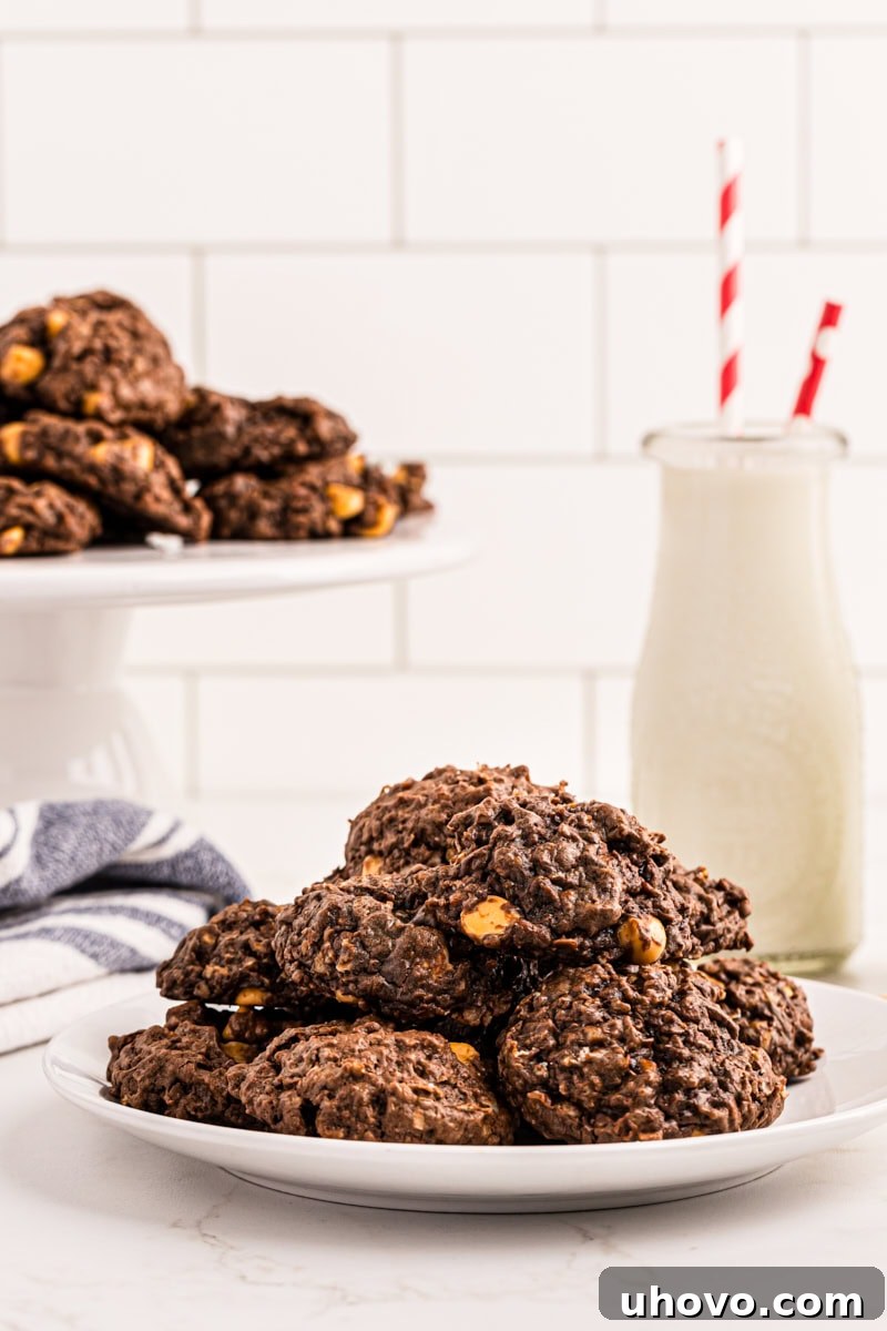 Pile of chewy chocolate butterscotch cookies on a white plate, ready to be served.