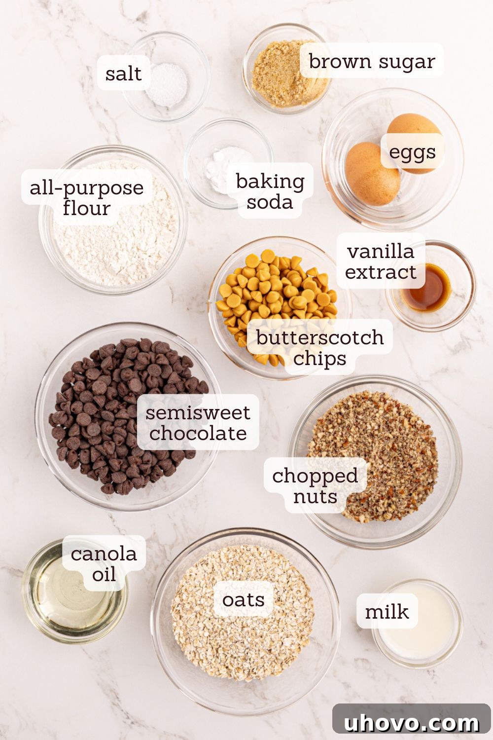 Overhead view of various ingredients for chocolate butterscotch cookies laid out on a baking surface, ready for mixing.