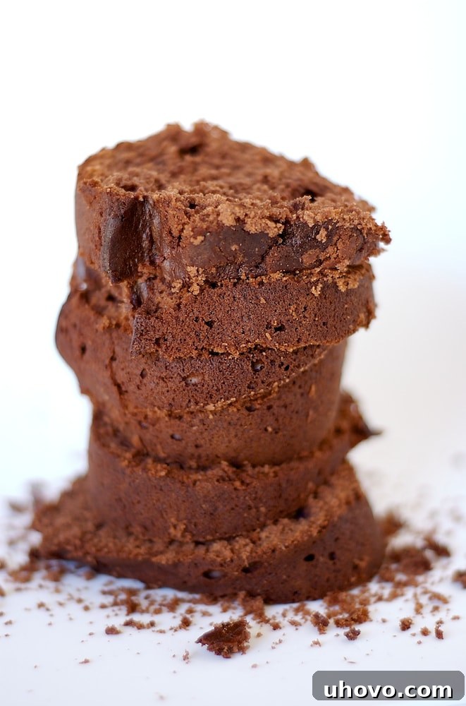 Slices of Chocolate Cream Cheese Pound Cake stacked on a white surface, showcasing its rich texture.