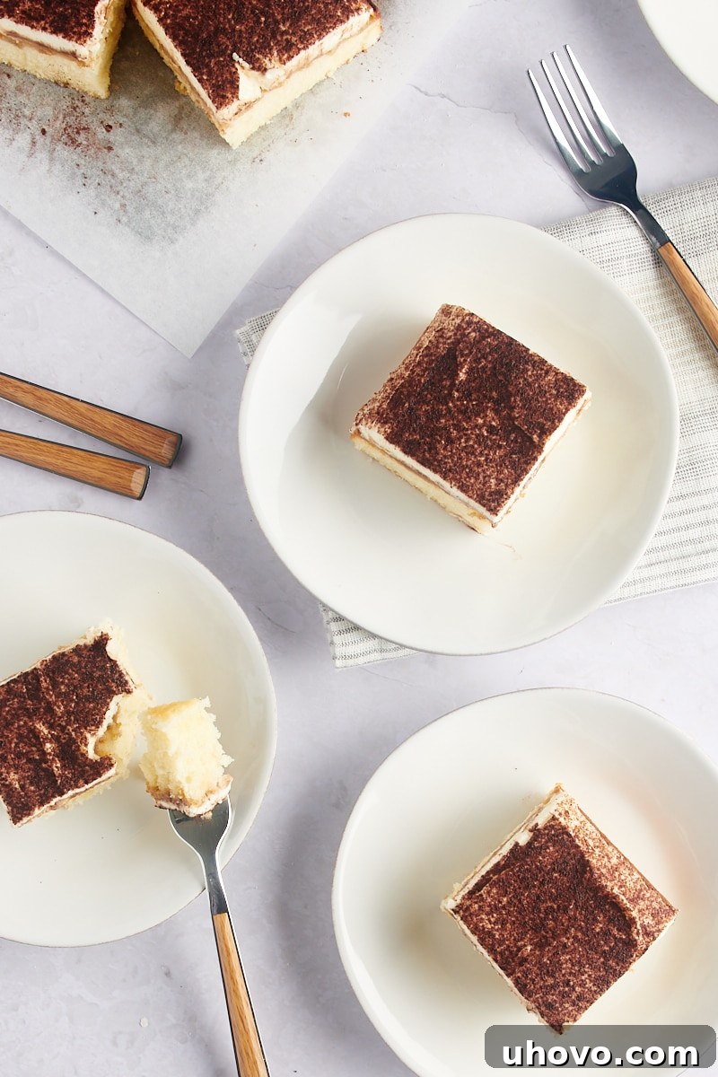 Overhead view of tiramisu cake slices on white plates, ready to be served.