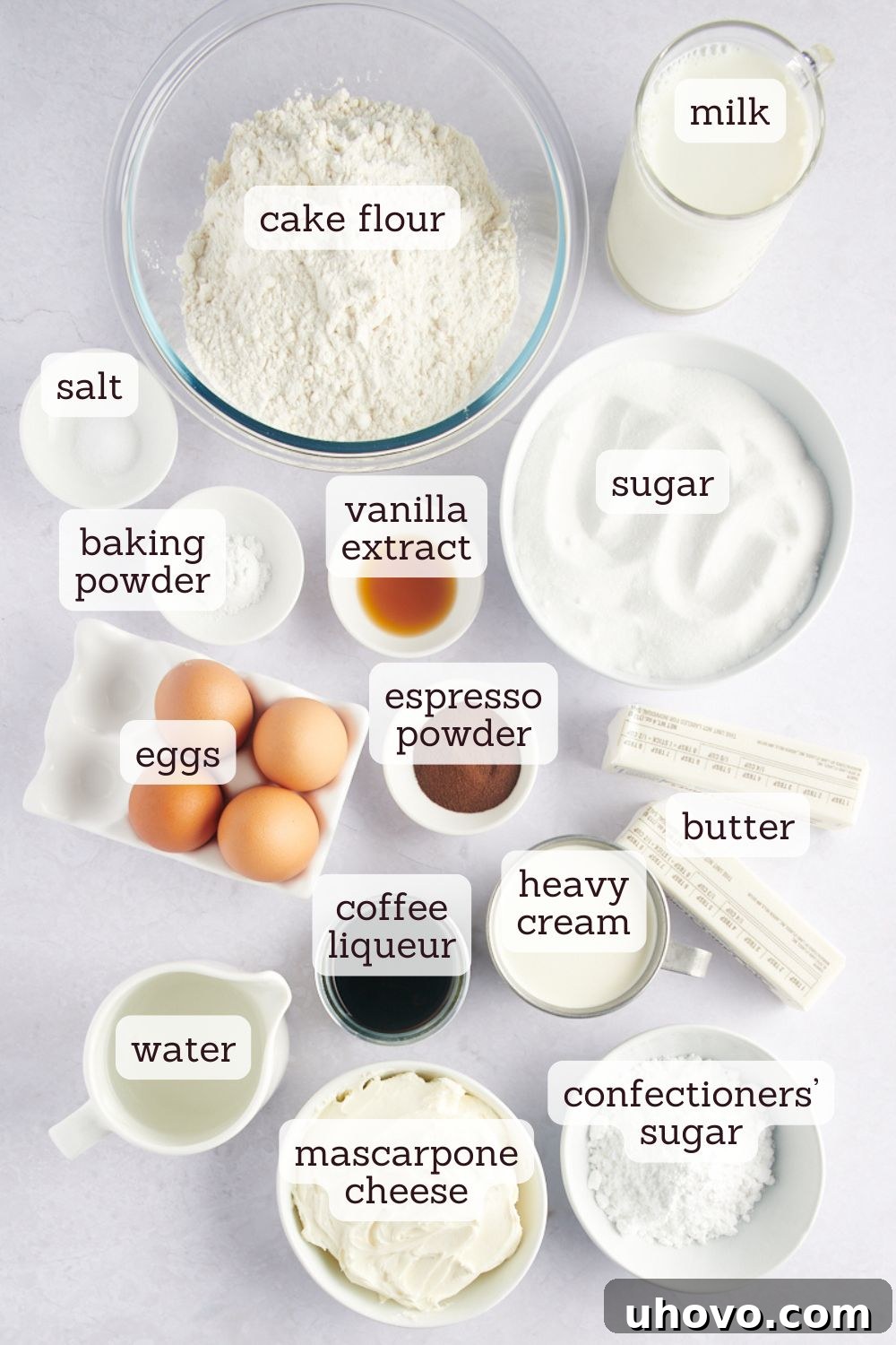 Overhead view of ingredients for tiramisu cake laid out on a surface.
