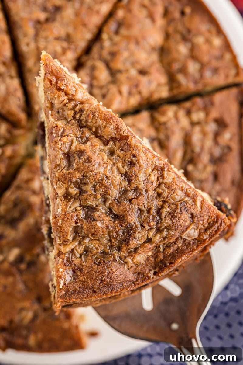 A perfect slice of apple streusel coffee cake, lifted by a spatula, showcasing its beautiful layers