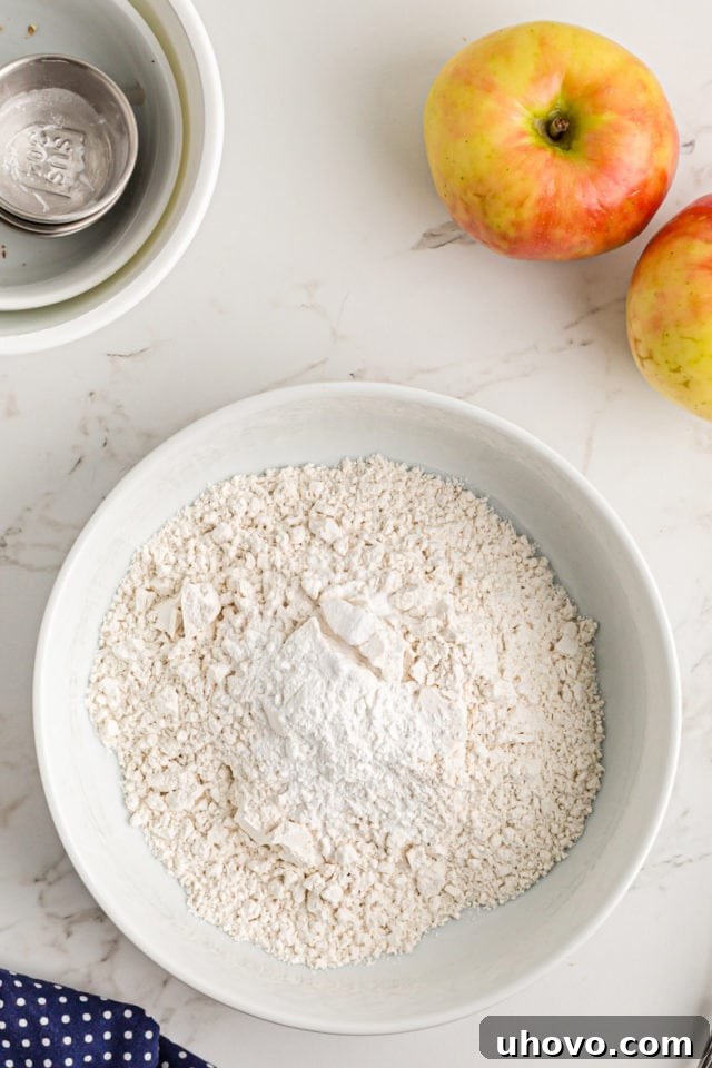 Overhead view of dry ingredients (flour, baking powder, baking soda, salt) for the coffee cake being whisked together in a bowl