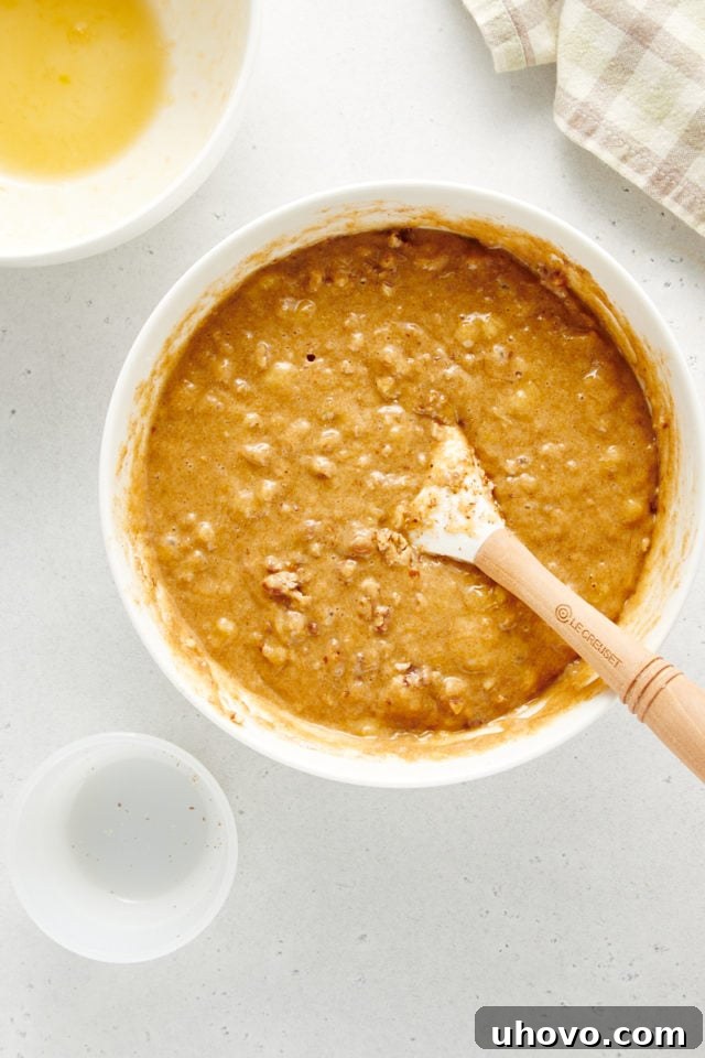 Overhead view of banana nut muffin batter, now mixed and ready for portioning, in a white mixing bowl.