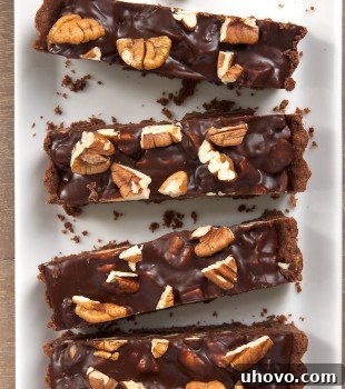 overhead view of slices of Chocolate Pecan Tart on a long white tray