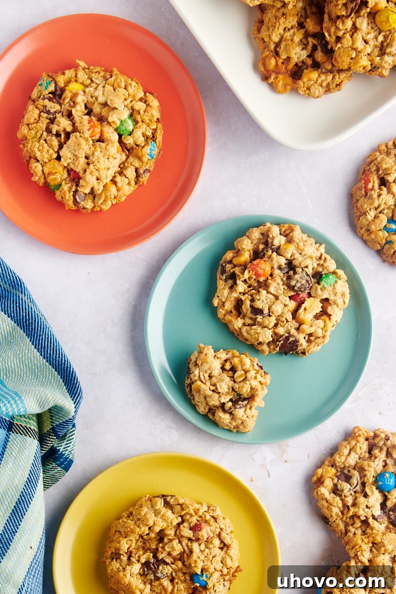 Overhead view of monster cookies arranged on three different plates, ready to be served or shared.