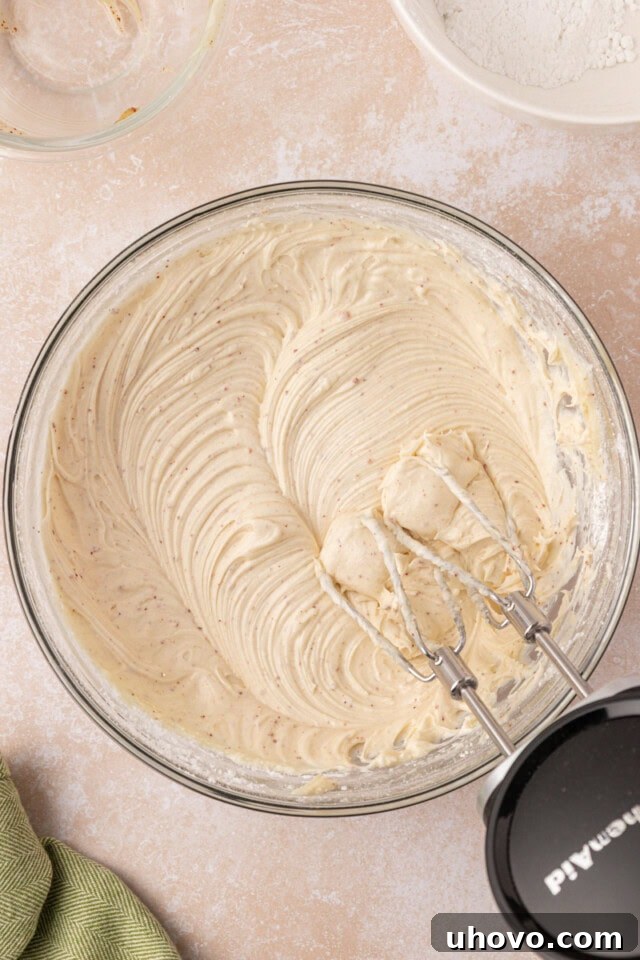 A mixing bowl filled with luscious browned butter cream cheese frosting, smooth and ready to be spread, showcasing its creamy texture.