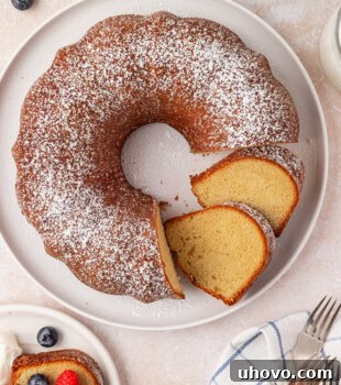 Overhead view of partially sliced buttermilk pound cake topped with powdered sugar.