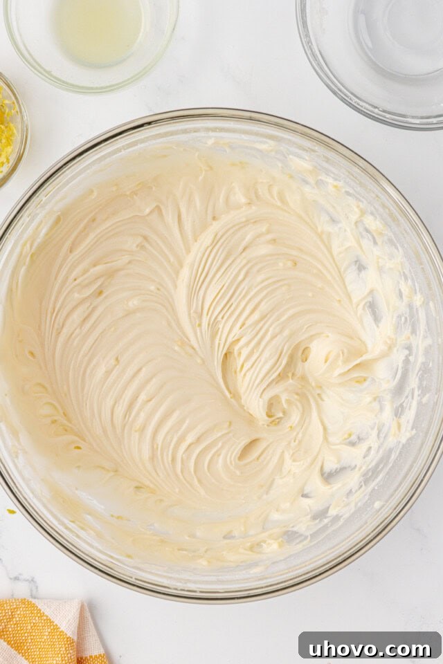Close-up of the finished, creamy, and vibrant lemon cream cheese filling for whoopie pies in a mixing bowl, showcasing its smooth texture.