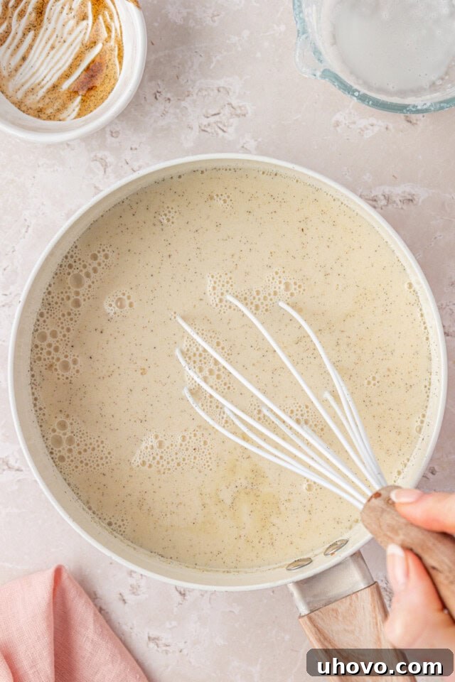 vanilla panna cotta mixture in a saucepan being whisked