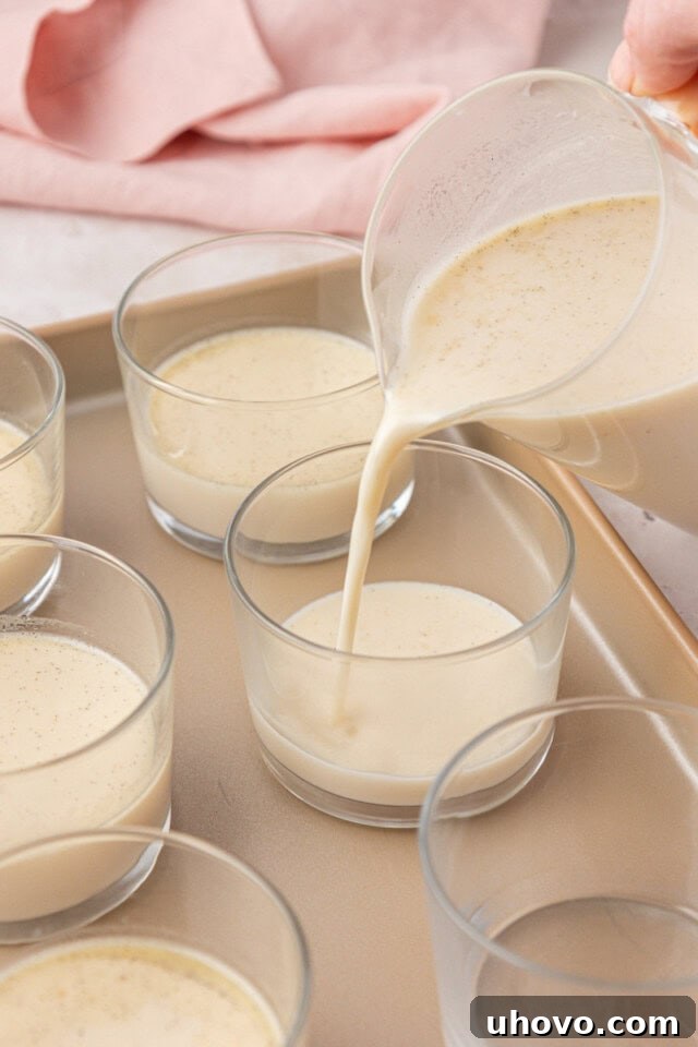 panna cotta mixture being poured into dessert glasses