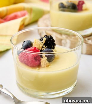 lemon posset in a clear glass topped with berries