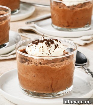 servings of Chocolate Mousse in clear glasses set on small white plates