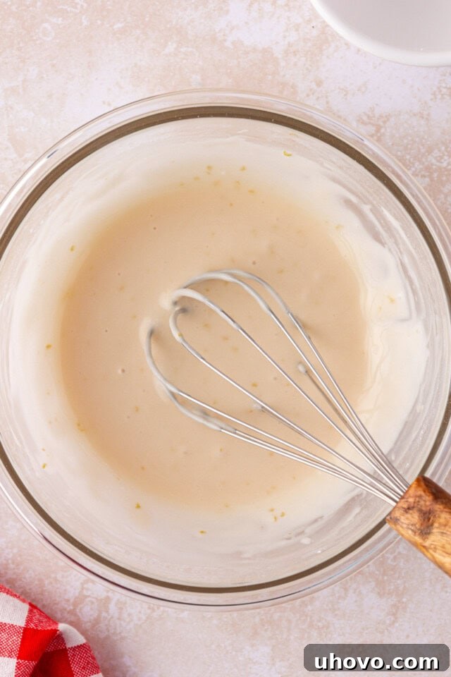 overhead view of sweet cream glaze in a mixing bowl with a whisk
