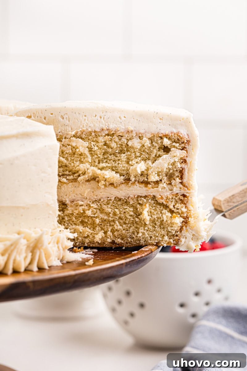 a slice of vanilla layer cake being removed from the remaining cake