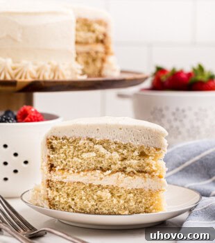 slice of soft vanilla layer cake topped with fluffy vanilla buttercream frosting