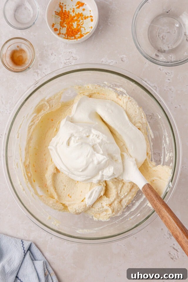 whipped cream folding into no-bake cheesecake mixture