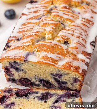 partially sliced blueberry ricotta loaf cake with lemon glaze